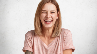 glad-pleasant-looking-woman-with-sincere-broad-smile-laughs-happily-camera-listens-anecdotes-isolated-white