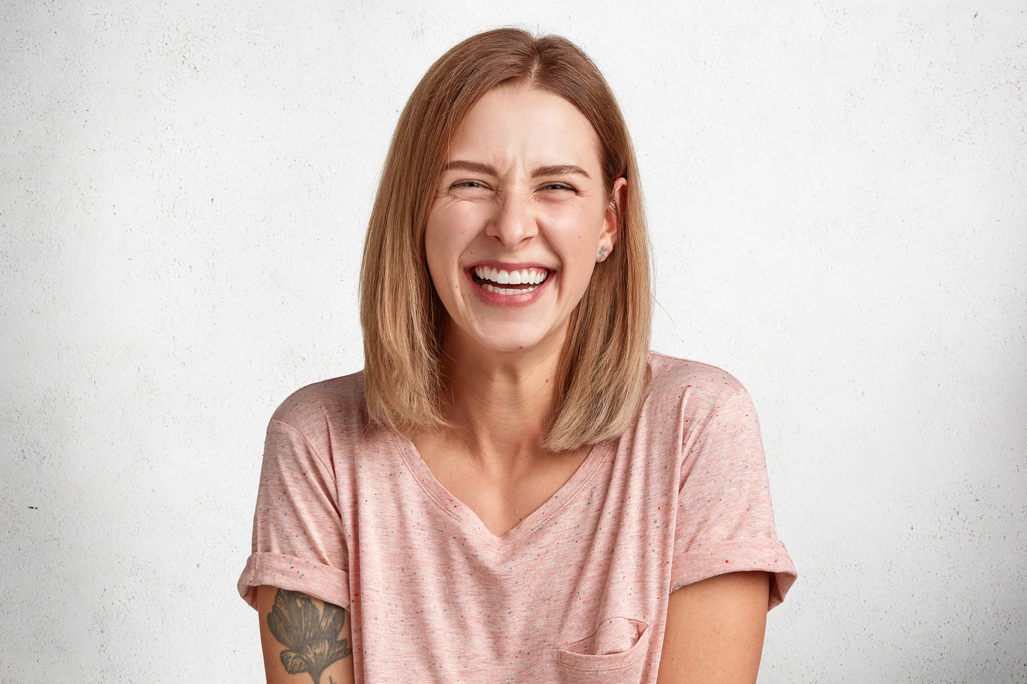 glad-pleasant-looking-woman-with-sincere-broad-smile-laughs-happily-camera-listens-anecdotes-isolated-white