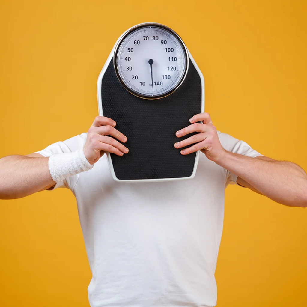 young-sports-man-hiding-face-weight-scales