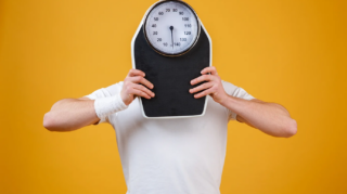 young-sports-man-hiding-face-weight-scales
